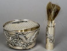 A Chinese silver shaving set
Comprising: a brush and bowl, each decorated with a dragon.