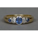 An 18 ct gold five stone sapphire and diamond ring The three sapphires interspersed with two