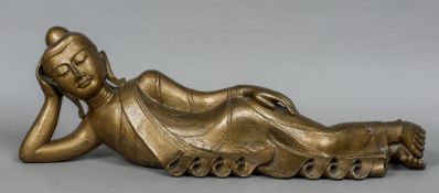 A gilt painted carved wooden figure of Buddha Modelled in reclining position. 90 cm long.