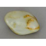 A Chinese green and russet jade boulder Of natural form. 7 cm wide.