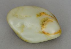 A Chinese green and russet jade boulder Of natural form. 7 cm wide.