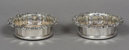 A pair of George IV silver bottle coasters, hallmarked Sheffield 1825 and 1828,