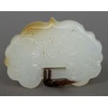 A Chinese carved white jade pendant Of serpentine form, worked with floral sprays. 4 cm wide.