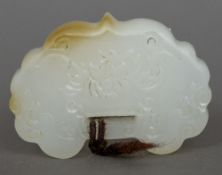 A Chinese carved white jade pendant Of serpentine form, worked with floral sprays. 4 cm wide.