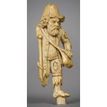 A 19th century Dieppe carved ivory figure of a beggar Modelled in tatty torn clothing and wearing a