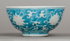 A Chinese porcelain bowl Relief moulded with lotus strapwork on a turquoise ground,