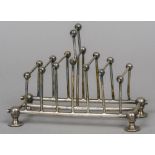 An Arts & Crafts silver plate toast rack, formed in the Christopher Dresser manner 17.5 cm long.