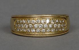 A diamond set 9 ct gold band Set with approximately thirty-six small diamonds.