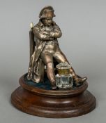 A late 19th century desk stand Formed as seated Napoleon at the front of a clear glass inkwell,