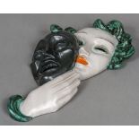 An Art Deco Goldscheider wall mask Formed as a young woman holding a mask,