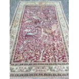 A Middle Eastern wool carpet The wine red field extensively filled with exotic birds amongst