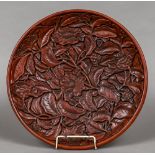 A Chinese cinnabar lacquer charger Extensively carved with lotus flowers and foliage opposing