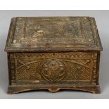 A 19th century carved box The hinged lid and sides with Gothic style panels with cherub masks.