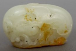 A Chinese carved green and russet jade pebble Worked to one side with a dragon eyed Wen goldfish.