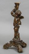 An 18th century carved wooden model of cupid Of typical form, standing on three outswept legs.