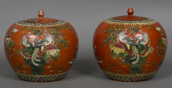 A pair of Chinese orange ground ginger jars Each decorated with various birds amongst trees and