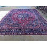 An Isfahan wool carpet The wine red field enclosing an arabesque medallion with pendant palmettes