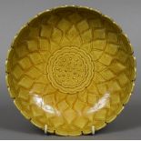 A Chinese mustard yellow ground dish With lappet form rim and central floral motif,