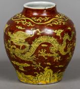 A Chinese porcelain vase Decorated with five clawed dragons within stylised clouds on a red ground.