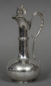 A French silver claret jug The thumbpiece formed as a griffin holding a shield,