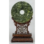 A Chinese carved green hardstone bi-disc Of typical form,