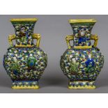 A pair of 19th century Chinese porcelain vases Each with twin mask handles and decorated in relief