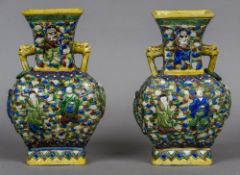 A pair of 19th century Chinese porcelain vases Each with twin mask handles and decorated in relief