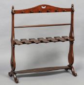 A 19th century mahogany whip and boot rack Of typical shaped trestle form,