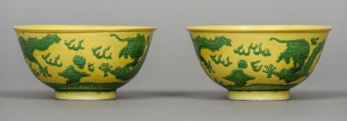 A pair of Chinese porcelain bowls Each decorated with dragons on a yellow ground,