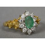 An 18 ct gold diamond and emerald cluster ring Of flowerhead form.