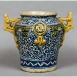 An antique maiolica drug jar With twin pierced handles, on a blue and white ground. 32.5 cm high.