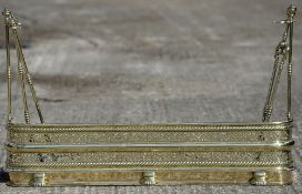 An early 19th century brass fender With integral detachable supports; and original brass fire irons.