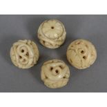 Four 19th century carved marine ivory balls Each approximately 2 cm diameter.