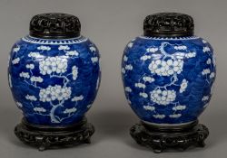 A pair of Chinese blue and white porcelain ginger jars with pierced and carved wood covers Each