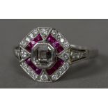 An Art Deco diamond and ruby set platinum target ring The centre stone approximately 0.5 carats.