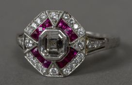 An Art Deco diamond and ruby set platinum target ring The centre stone approximately 0.5 carats.