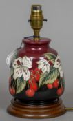 A modern Moorcroft pottery table lamp With red ground and cherry decoration. 24 cm high.