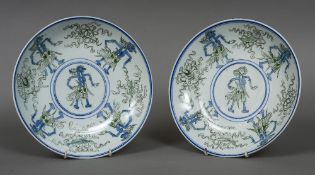 A pair of unusual Japanese porcelain dishes Each decorated with stylised figures and various