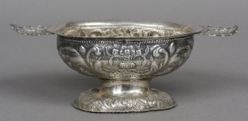 A repousse decorated Continental twin handled silver footed bowl With scrolling foliate decoration.