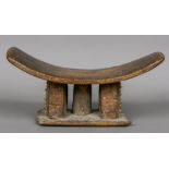 An African tribal carved wooden headrest Of typical dished form. 47.5 cm wide.