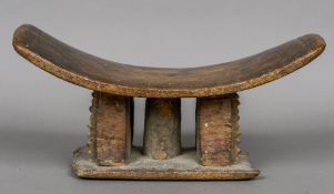 An African tribal carved wooden headrest Of typical dished form. 47.5 cm wide.
