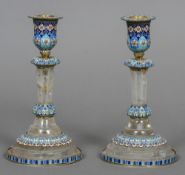 A pair of enamel decorated and silver mounted rock crystal candlesticks Each with floral and lappet