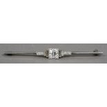 An Art Deco 18 ct white gold and platinum diamond set bar brooch The central stone approximately 0.