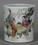 A Chinese porcelain brush pot Decorated with gaming figures seated at a table in a garden,