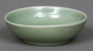 A Chinese celadon porcelain shallow bowl The centre anhua decorated with a floral spray,