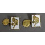A pair of white enamelled yellow metal cufflinks Each decorated with a pair of tennis rackets and