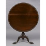 A 19th century mahogany tilt-top tripod table The circular top with a carved edge above a turned