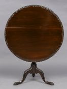 A 19th century mahogany tilt-top tripod table The circular top with a carved edge above a turned