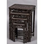 A late 19th century Chinese carved wooden quartetto nest of tables Each top decorated with a dragon.