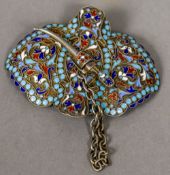 A Russian enamel decorated silver buckle With floral scrollwork ground,